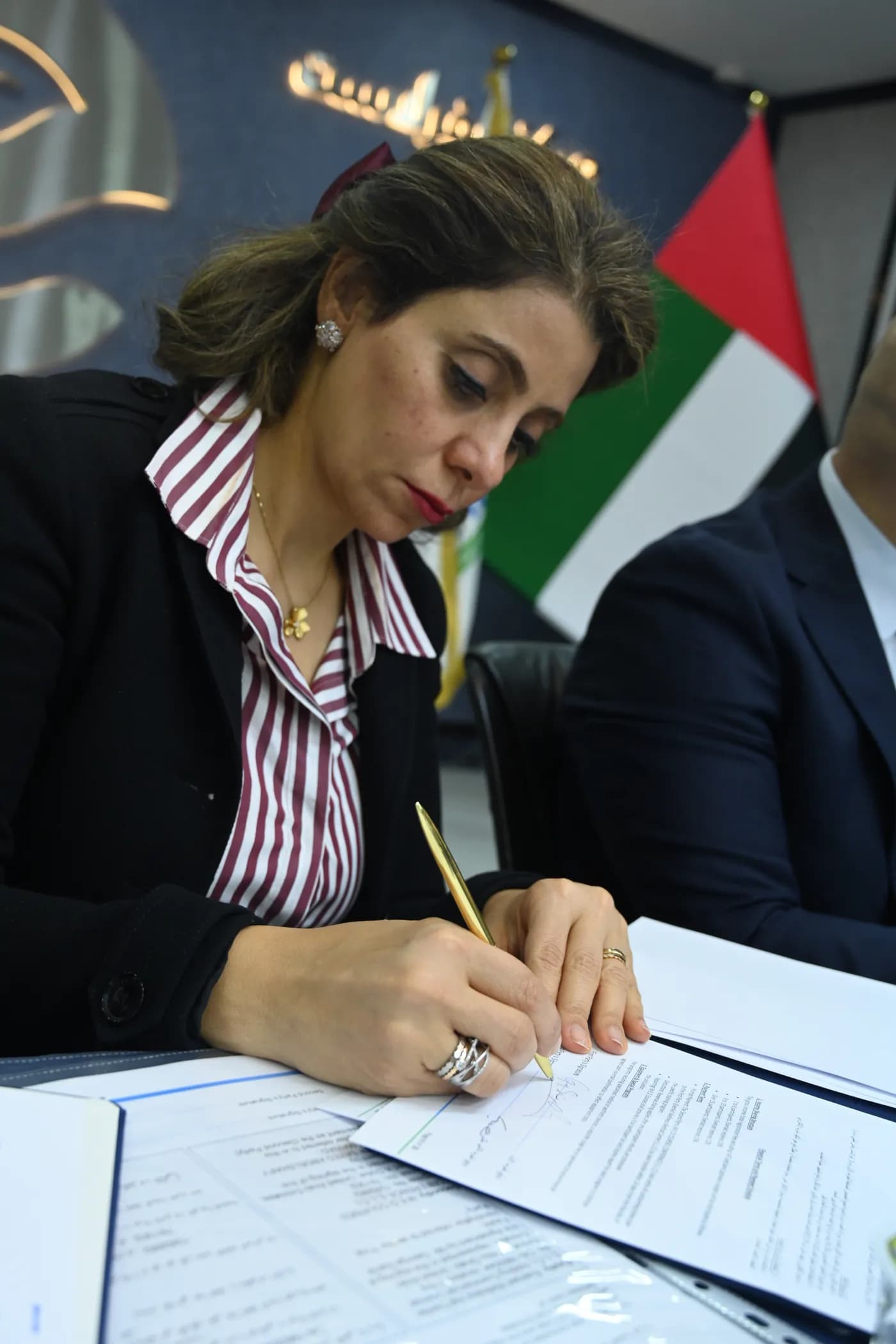 Dr. Christeen Youssef signing the cooperation agreement with the American Board of Education in Abu Dhabi.
